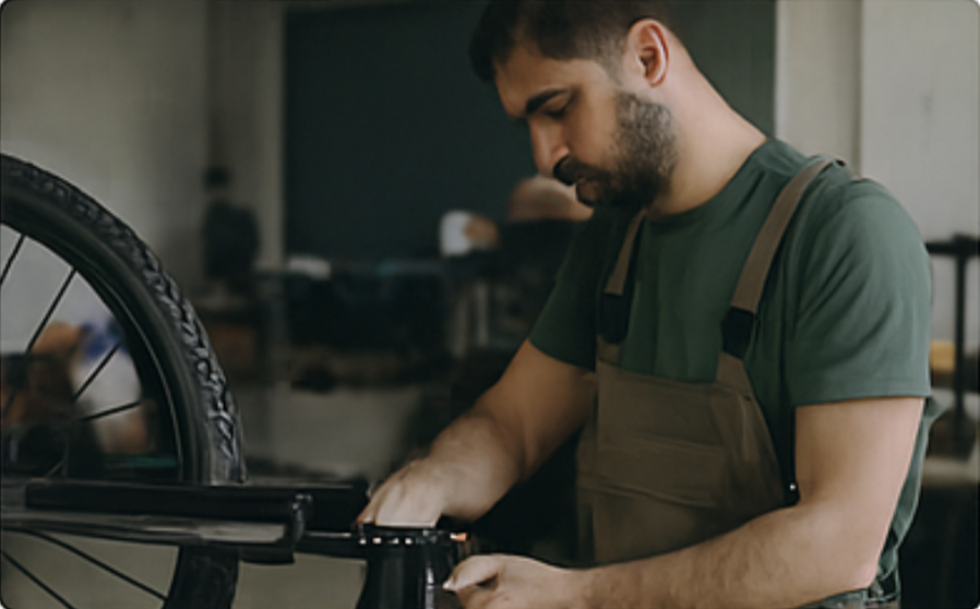 Mécanicien réparant un vélo dans un atelier de reconditionnement de La Roue Tourne